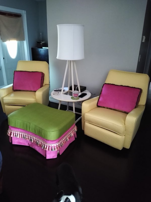Pair of yellow armchairs with a pink tufted tasseled ottoman