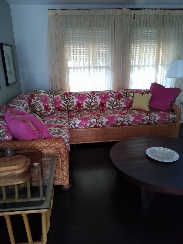 Sectional sofa reupholstered in bold pink floral fabric with matching pillows